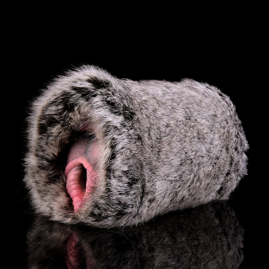 Gray faux-fur dual-hole sex toy with two inner pink openings on a compact tube