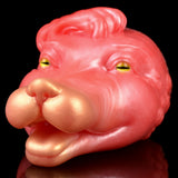 Pink/red creature fleshlite with yellow-green eyes, curled head detail; angled view