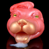 Pink/red creature head with yellow-green eyes, detailed snout and small blue tip