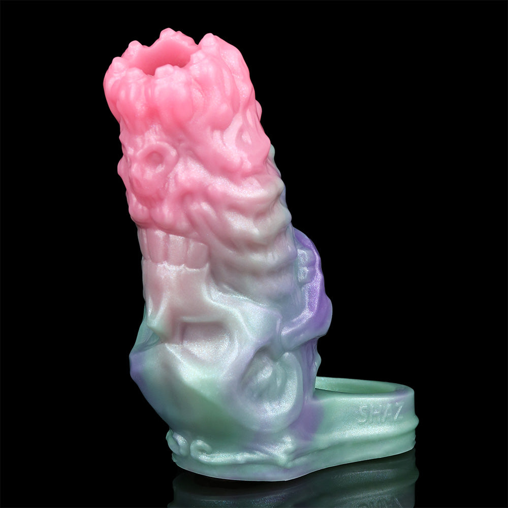 Cock sleeve extender angled view; pink top fades to purple and mint with a textured surface