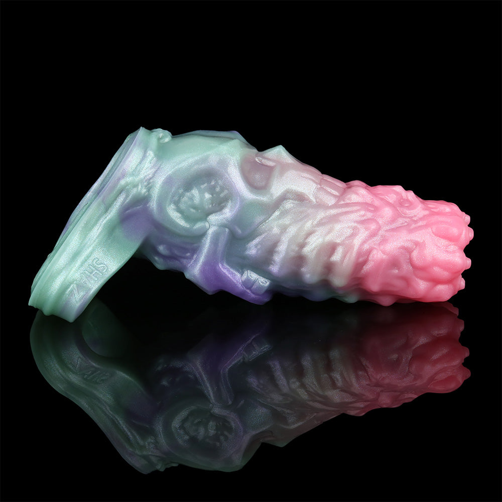 Cock sleeve extender on a base, shown from the left; iridescent pink, purple and turquoise