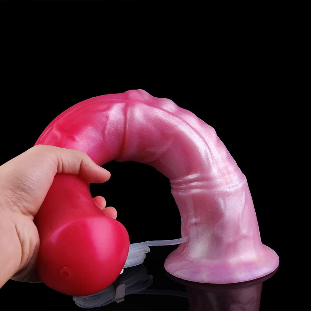 Rosa Pferde-Dildo mit Spritzöffnung; Hand hält die rote Pumpe