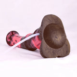 Horse-cock toy lying down with brown textured base and clear tube connection