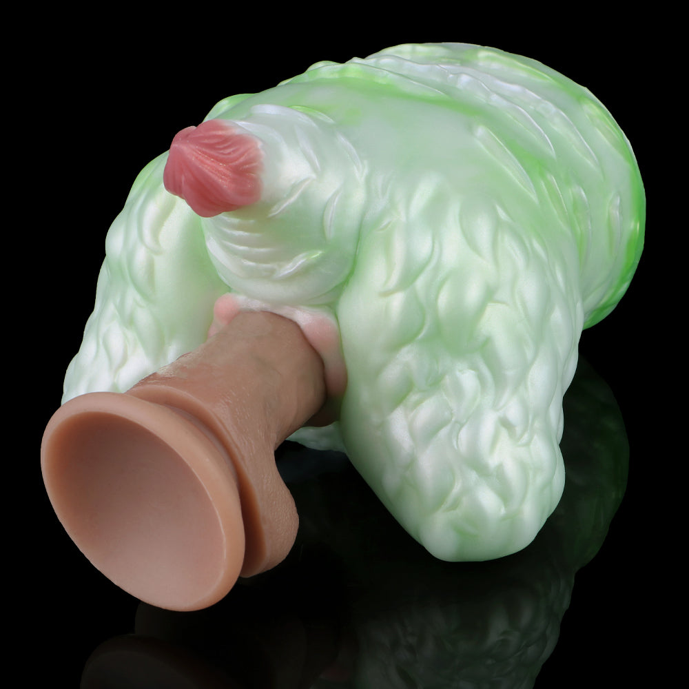 Green silicone butt plug with pink insert tip, hand holding the base, side view.