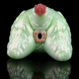 Green silicone butt plug with pink insert tip, contoured ridged texture, front view.