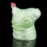 Green silicone butt plug with pink insert tip, side view showing ridged surface.