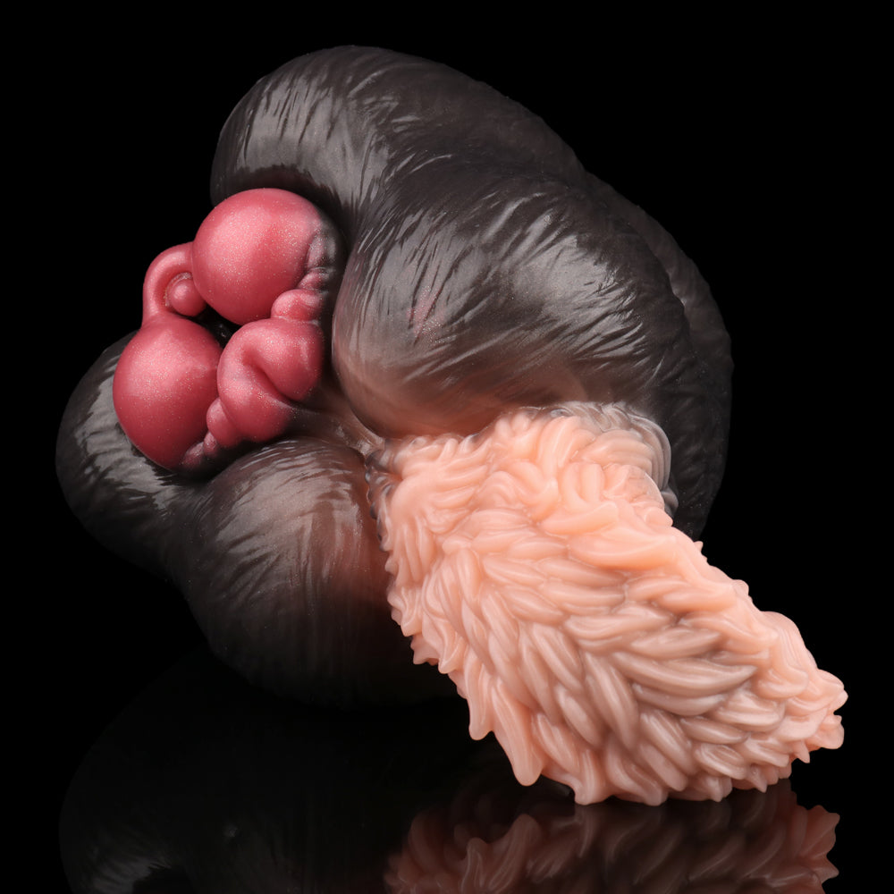 Close-up of dog-themed sex toy: black body with pale pink textured tip