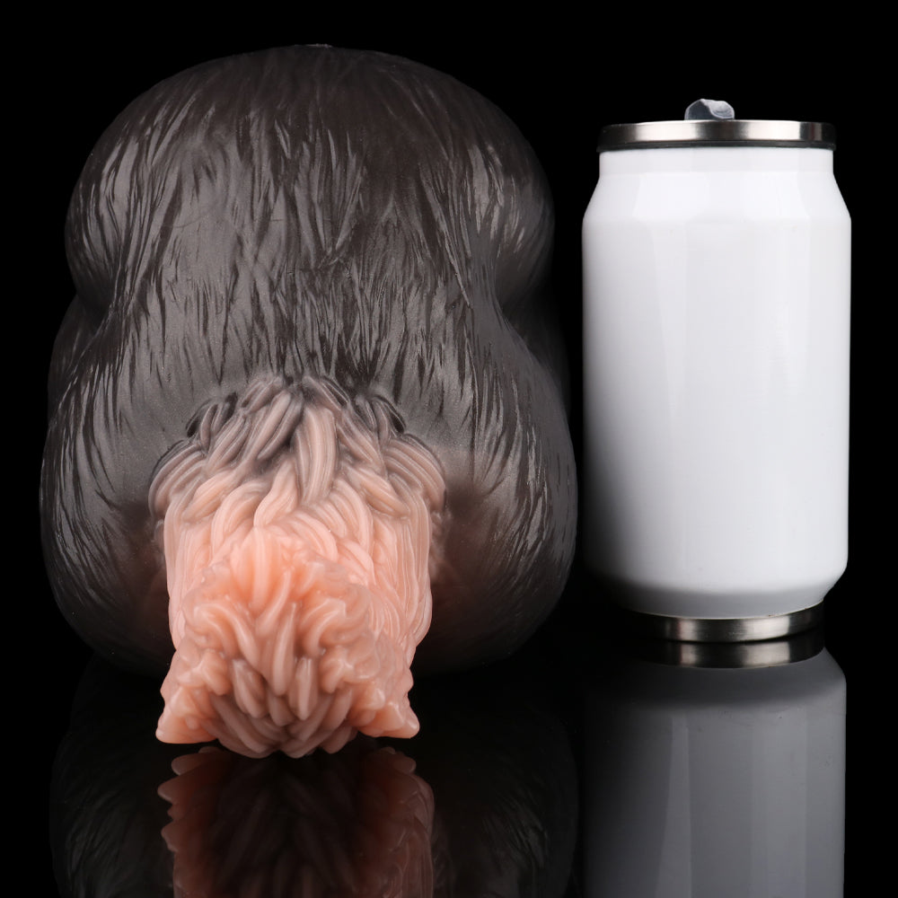 Front view of tailless dog sex toy: black body with pale pink insert; next to can