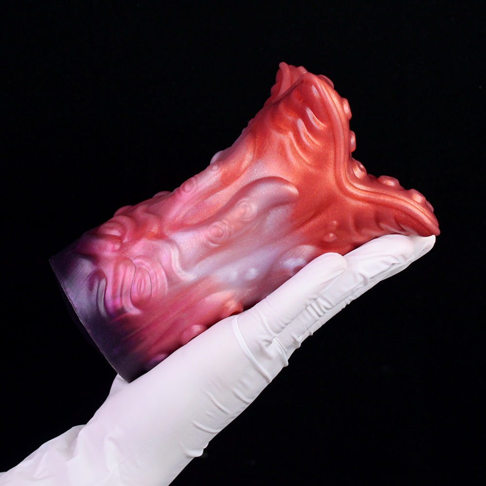 Red tentacle stroker held in white glove, glossy ridged alien texture