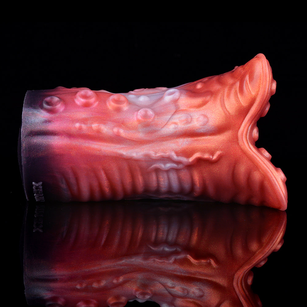 Close side view of red-and-pink ridged stroker tube with textured tentacle end