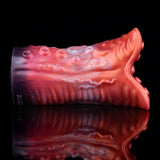 Close side view of red-and-pink ridged stroker tube with textured tentacle end
