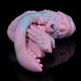 Pastel octopus figurine close-up with blue-green eye and textured tentacles