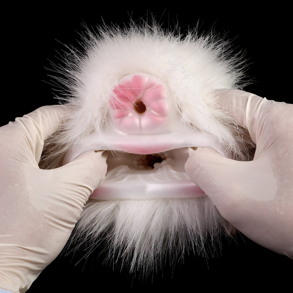 Nahaufnahme: weiße Kunstfell-Masturbatorhülle mit rosa Öffnung, von Handschuhen gehalten