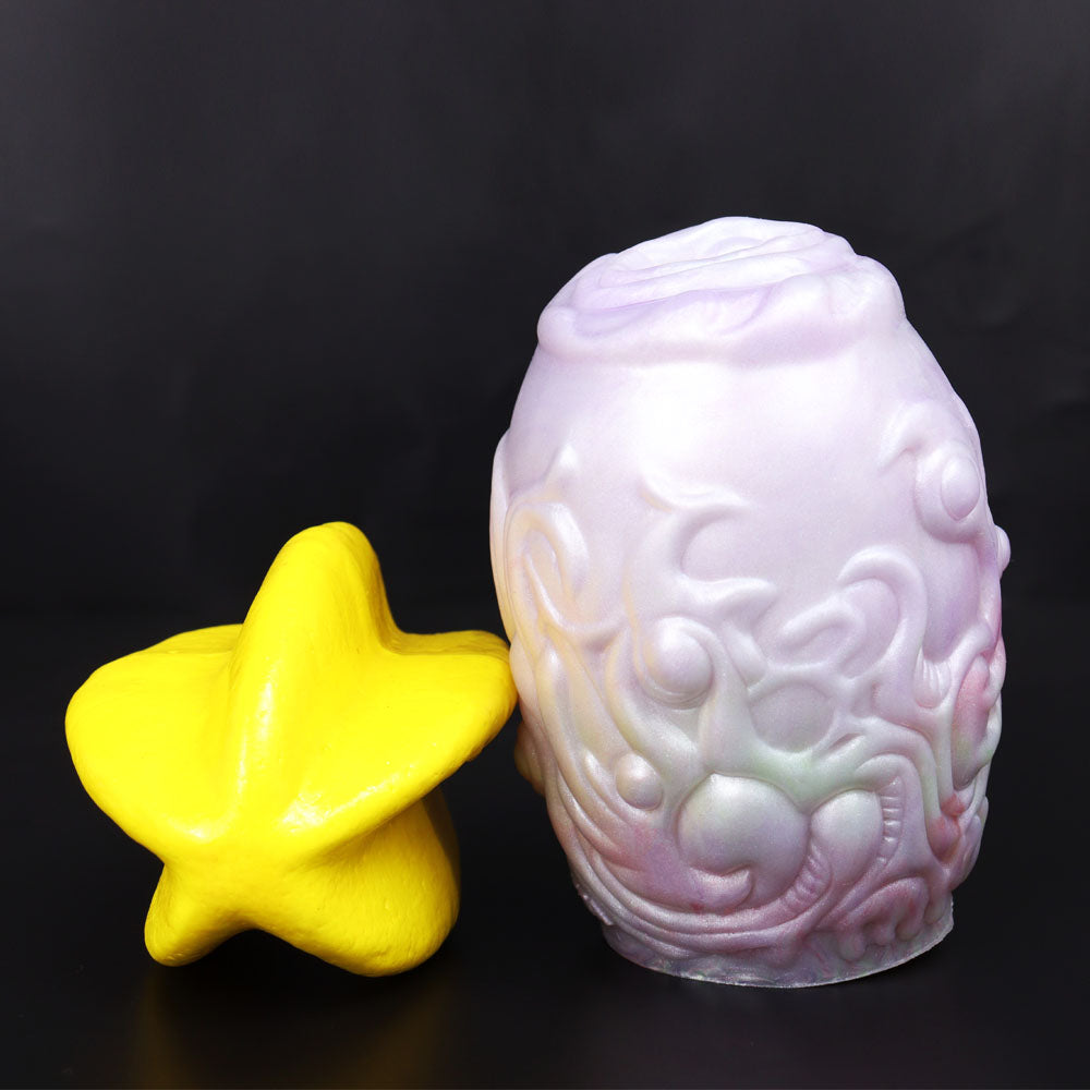 Dragon Egg male stroker with yellow star-shaped piece, detailed pale textured surface
