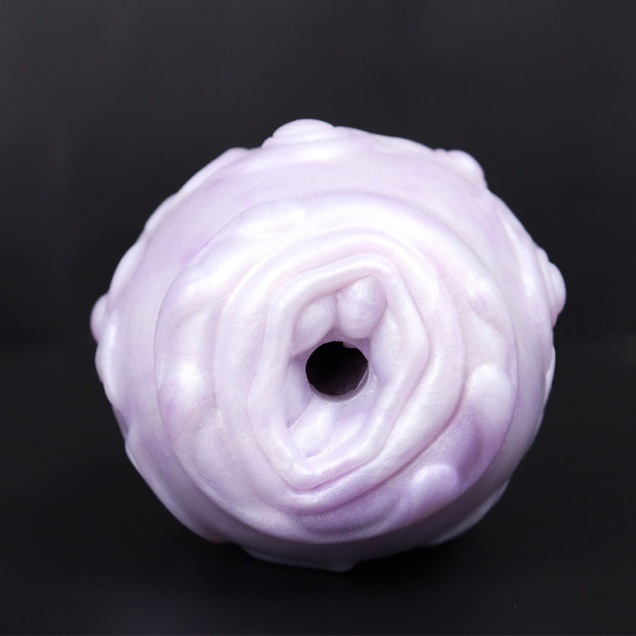 Pink-and-white dragon egg-style sex toy end view with central hollow opening