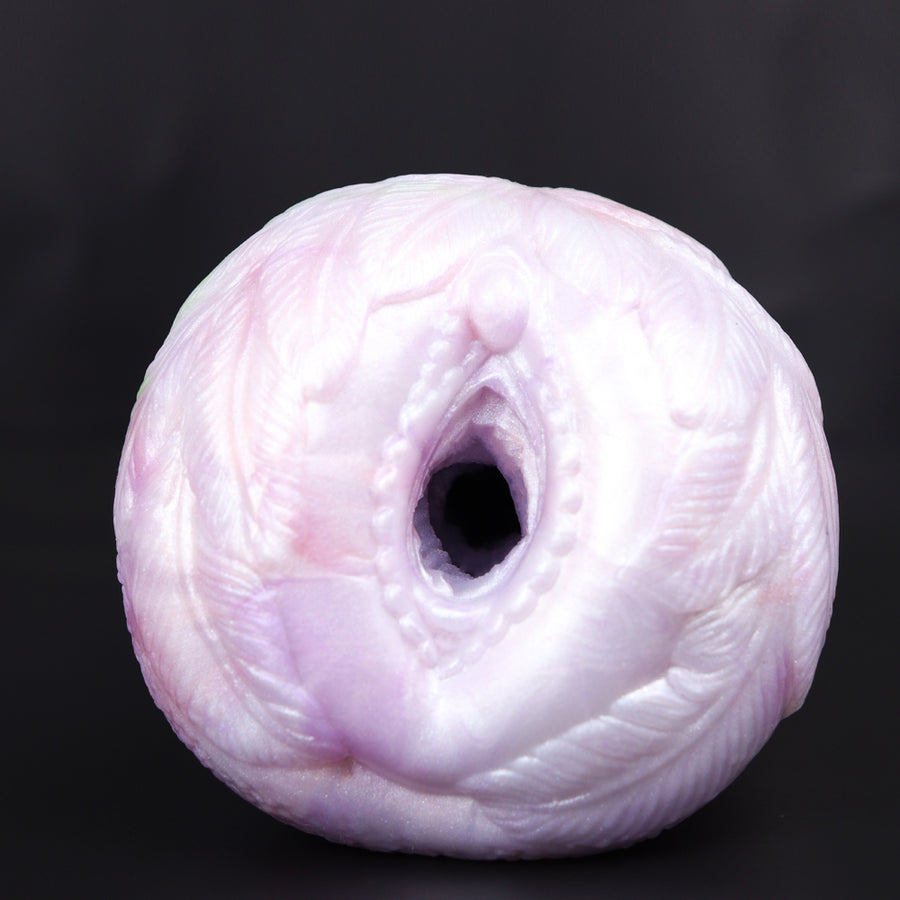 Pink and white pocket cup masturbator with dark oval opening and textured swirl surface