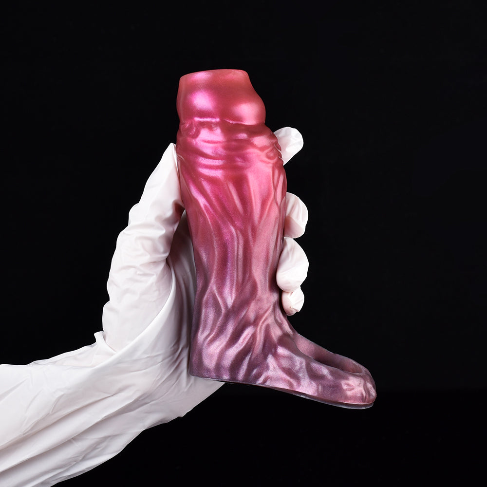 Fantasy cock sleeve extender in magenta-pink with textured ridges, worn with white gloves