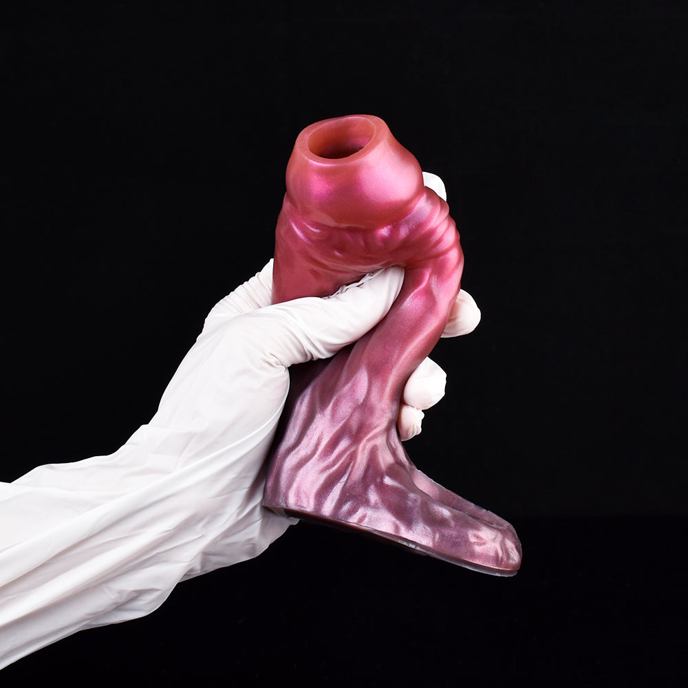 Fantasy cock sleeve extender in magenta-pink, curved shape held by white gloves
