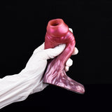 Fantasy cock sleeve extender in magenta-pink, curved shape held by white gloves