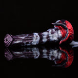 Close side view of fantasy squirting dildo, purple-gray body and red horn detail