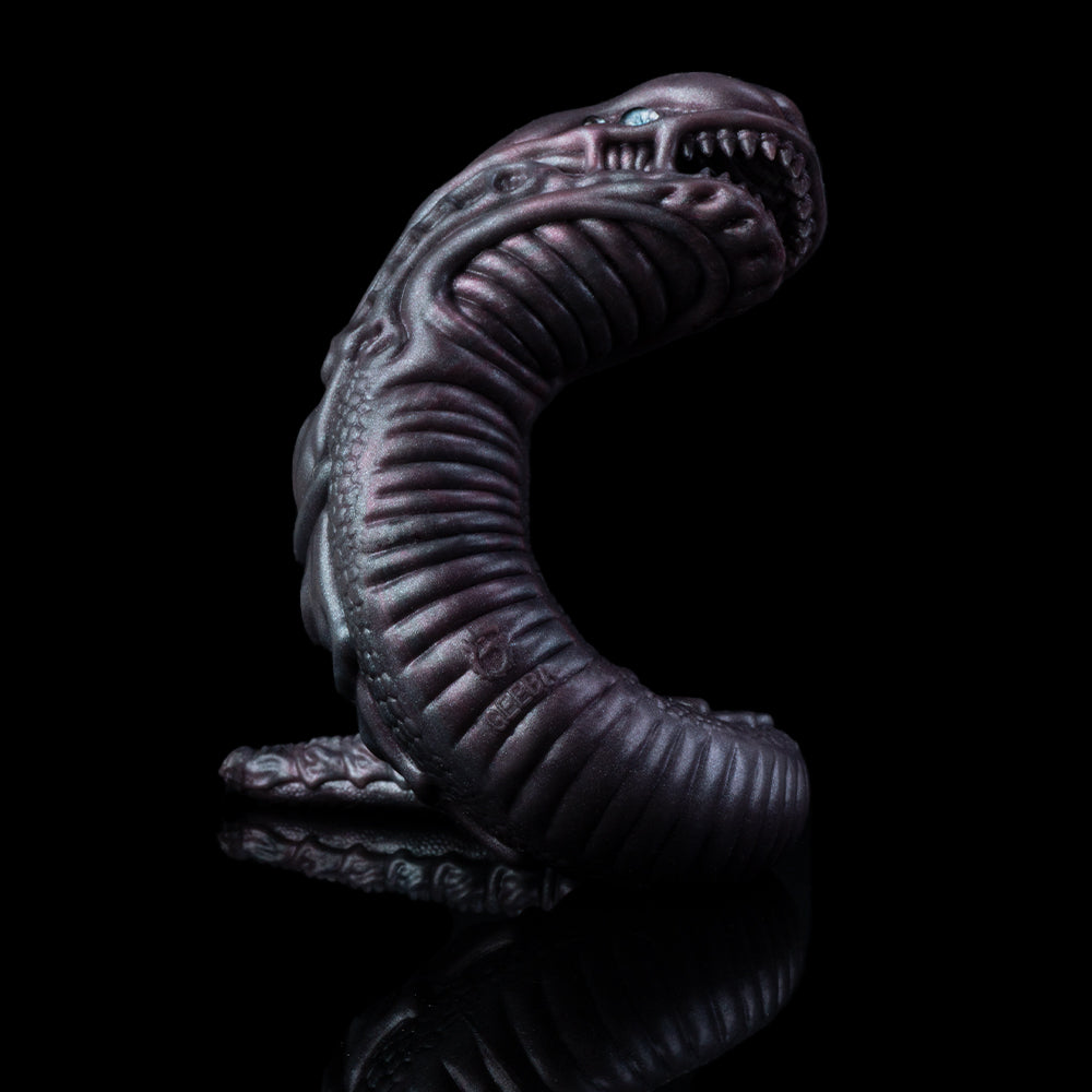 Curled snake creature toy head and torso with blue eyes, dark purple textured scales