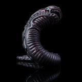 Curled snake creature toy head and torso with blue eyes, dark purple textured scales