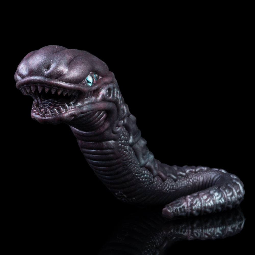 Snake creature toy with open mouth and blue eyes, dark purple scaly head and coils