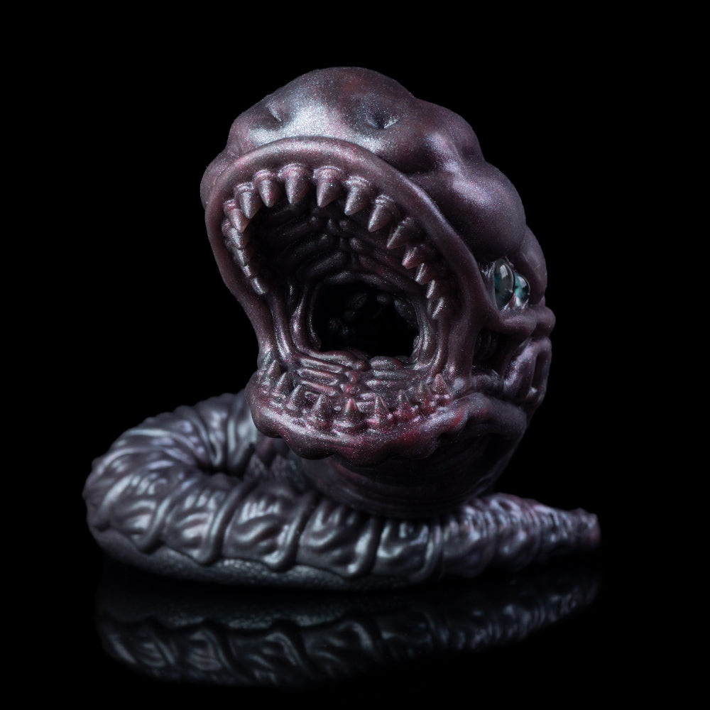 Sculpted snake creature toy with open mouth and blue eyes, dark purple curled posture