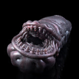 Close-up of snake creature toy head with open jaw and blue eyes, dark purple scales