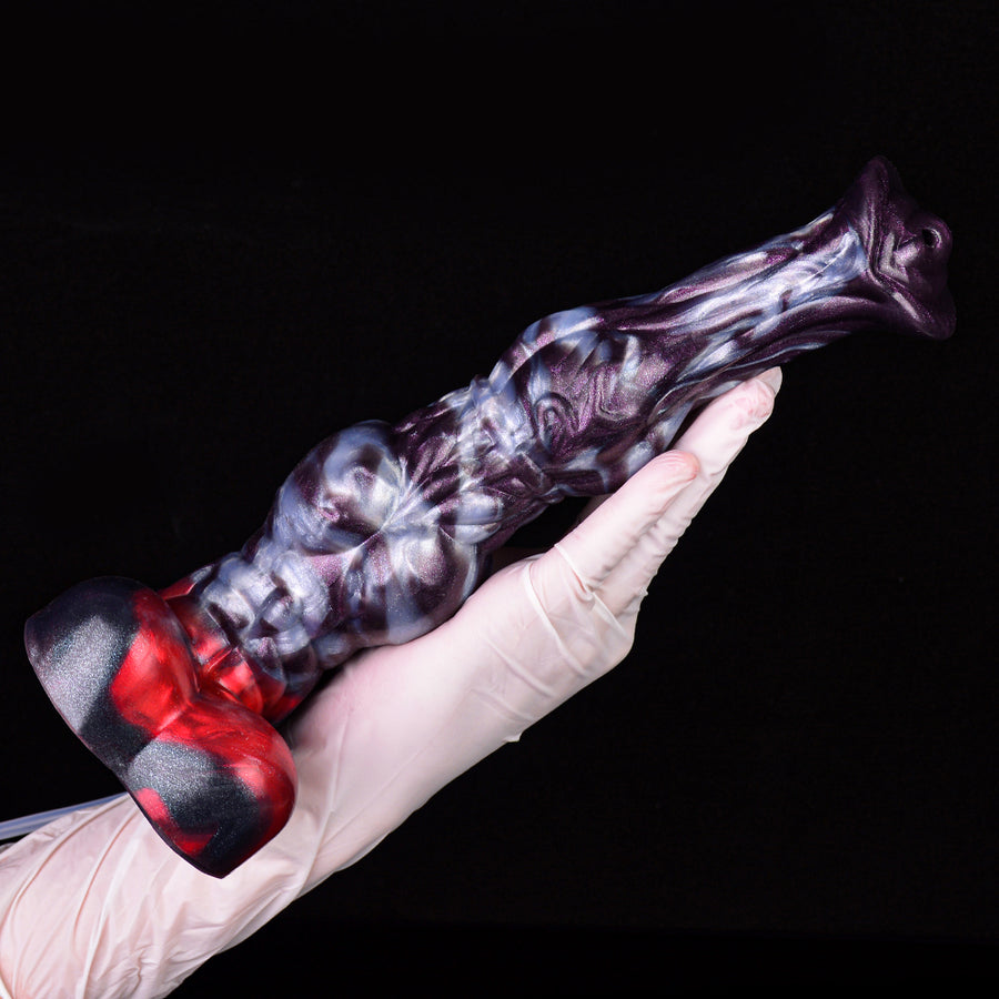 Purple-and-white patterned adult dildo with knot base, held by white-gloved hand