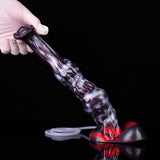 Gehaltener lila Squirting-Dildo, rote Knotenzone, transparentes Schlauchstück auf dunklem Boden