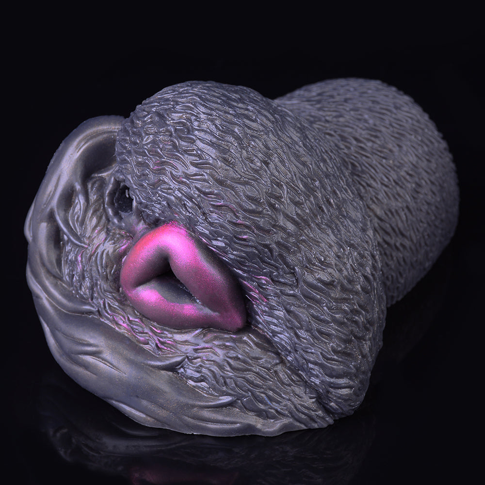 Close-up of textured animal-shaped dual-hole masturbator, dark gray with purple opening