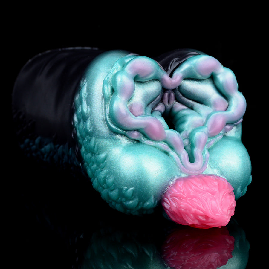 Alien-themed stroker sleeve close-up: teal molded interior with pink inner bulb