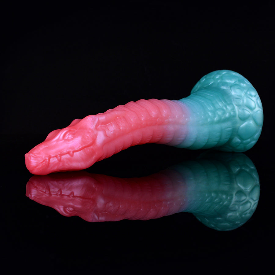 Curved sex toy with pink tip and teal-blue base, glossy textured dragon pattern