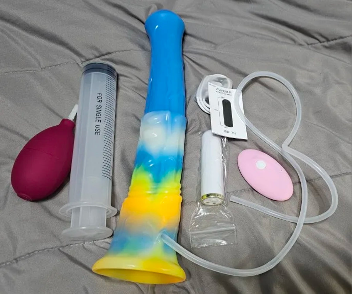 Customer photo of the Bael 11-inch rainbow ejaculating horse dildo and equine vibrator with syringe, squeeze bulb, luminous function and wired controller displayed on a bed