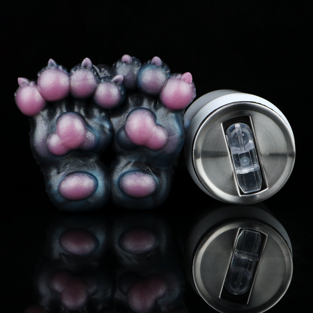 Monster paw-shaped novelty toy with pink toe pads next to silver bottle opener