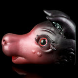 Pink and dark gray cat figurine side close-up with red glowing eye and ear