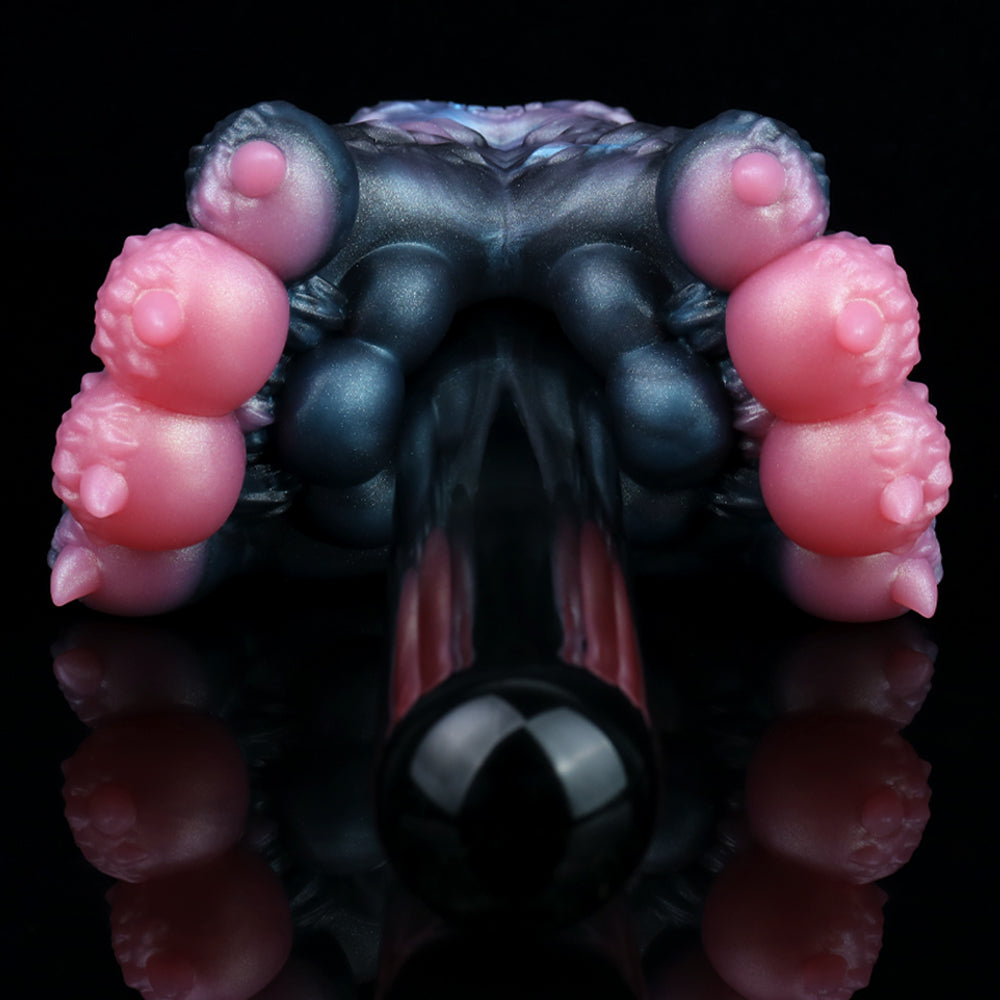 Dark blue and black textured toy with pink nubs at both top corners, close-up