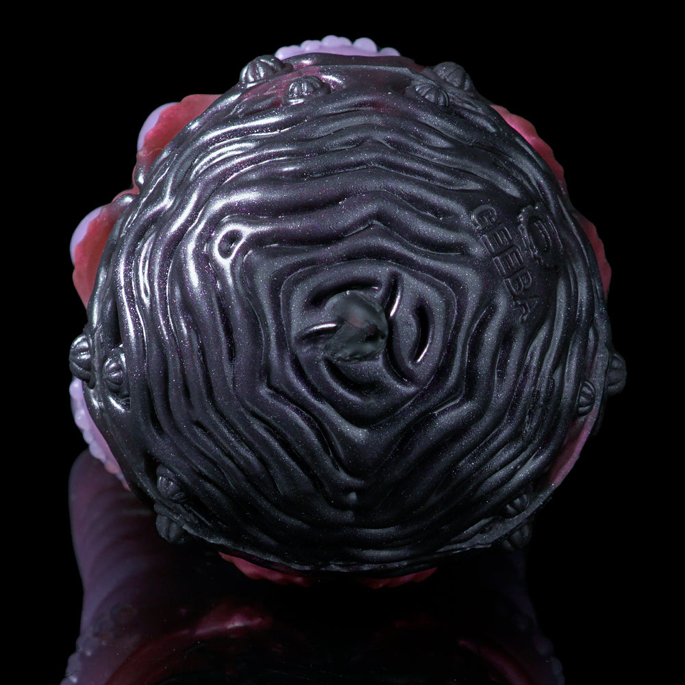 Close-up dark purple silicone octopus head with swirling ridges and small face details