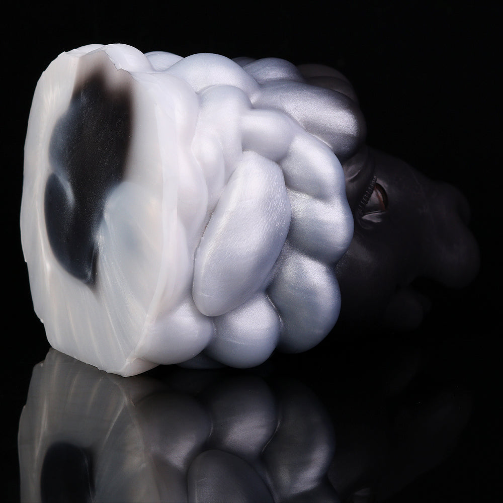 Animal figurine close-up of swirled mane, glossy black and white tones, partial orange eye