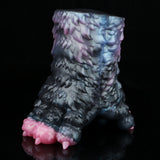 Dark blue and black textured toy with pink base edge and side nubs, angled