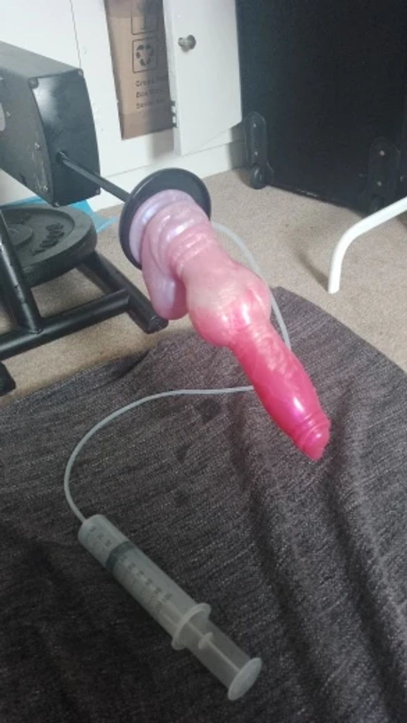 Customer photo of a pink fantasy ejaculating dildo with textured silicone shaft, flared suction base, transparent squirting tube and syringe system for realistic fluid play