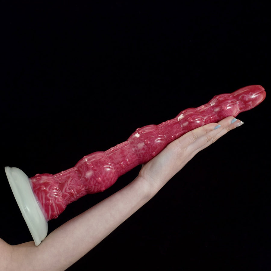 Pink octopus-tentacle butt plug laid out, with textured bead-like sections
