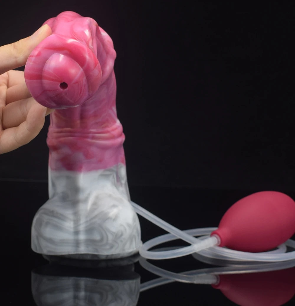 Pink translucent dildo top view in hand with attached clear tubing