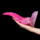 Oktopus-Buttplug in Handhaltung; gekrümmte Form mit Saugnoppen-Textur, pink