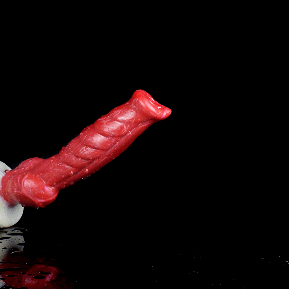 Red textured dildo detail with white base and clear tube, end toward left