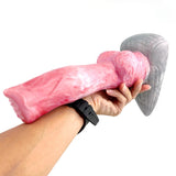 Pink fantasy werewolf sex toy held in hand with grey fin base