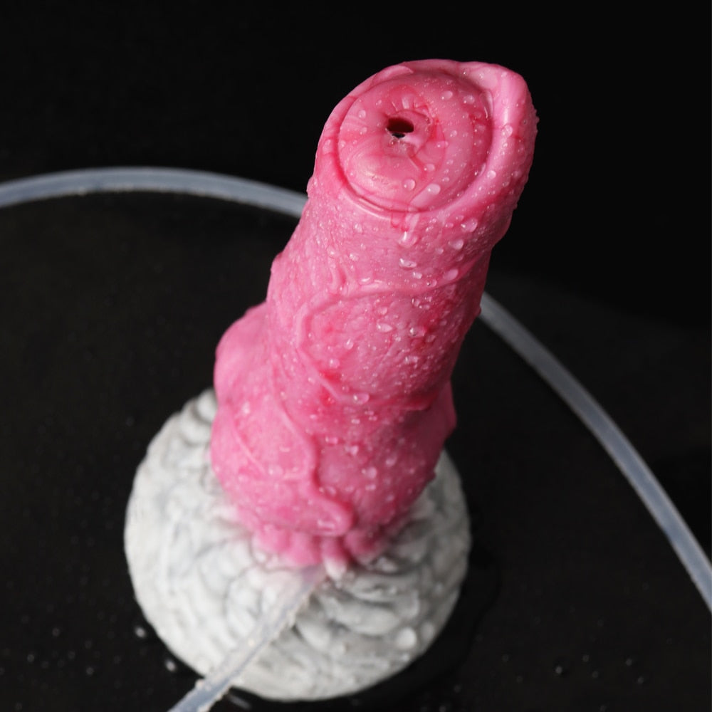 Close-up of pink realistic dog dildo, top outlet and curved clear tubing