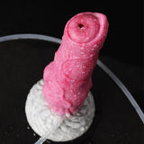 Close-up of pink realistic dog dildo, top outlet and curved clear tubing