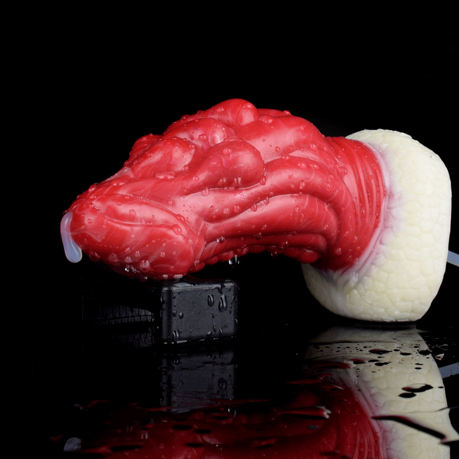Red dragon-themed anal plug with textured white base and squeeze tube attached